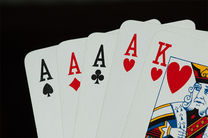 Five playing cards are revealed: an ace of spades, an ace of diamonds, an ace of clubs, an ace of hearts and a king of hearts.