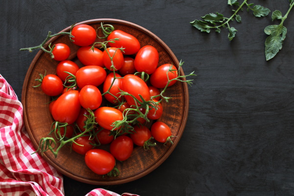 Bowl filled with red cherry-tomatoes. 