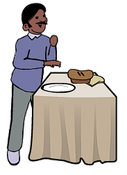 Un homme se tient à côté d’une table où se trouve un pain et un plateau.