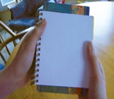 Notebooks are stacked on top of each other. The area of the first notebook is smaller.