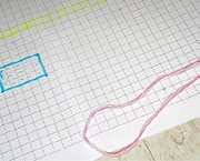 A gridded paperboard with two rectangles of different shapes and a piece of string.