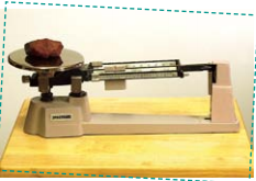 A rock is placed on a triple beam balance.