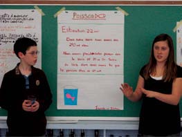Students display a poster on the board.