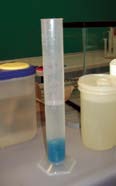 A graduated cylinder. It contains a quantity of liquid.